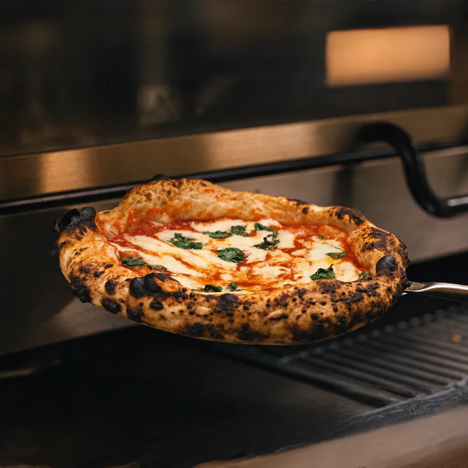 Napolilainen pizza pizzalapiolla uunin edessä