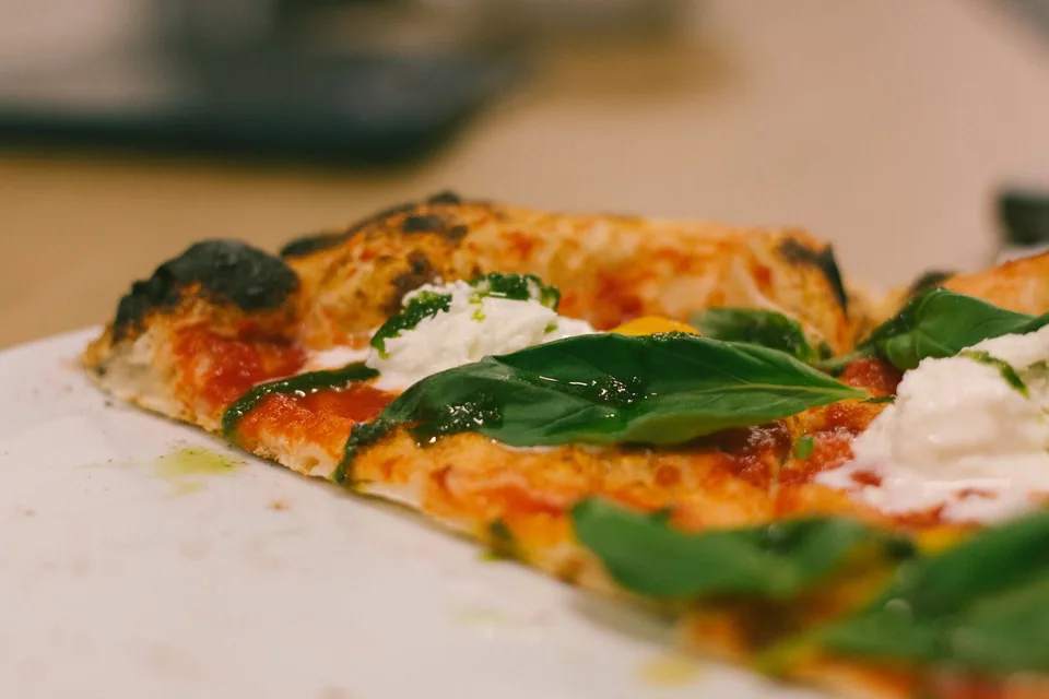 Lähikuva Preston pizzasta ja tuoreesta basilikasta